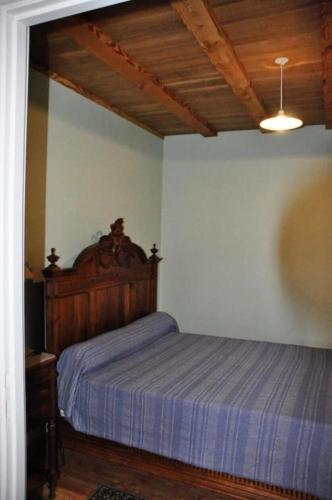 a bedroom with a bed with a wooden head board at Gîte de France Les belettes 3 épis - Gîte de France 4 personnes MAE-0304 in Chaumeil