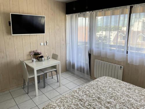 a bedroom with a table and a bed and a television at 0 - Studio pour 2 Personnes 134 in Aix-les-Bains