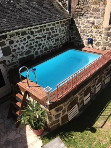 - une piscine avec un banc en bois à côté d'un bâtiment dans l'établissement Gîte de France Chirac du midi corrézien 3 épis - Gîte de France 6 personnes MAE-0324, à Turenne