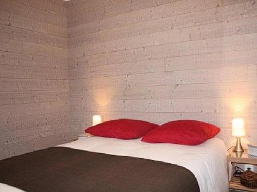 1 dormitorio con 1 cama con 2 almohadas rojas en Gîte de France à Saint-Germain-Lavolps 3 épis - Gîte de France 4 personn 314, 