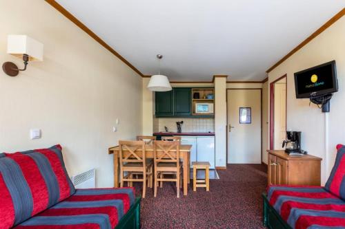 un salon avec deux canapés et une table ainsi qu'une cuisine dans l'établissement Résidence L'Alpaga - maeva Home - Appartement 2 pièces 5 personnes Confort MAE-4439, à La Salle Les Alpes