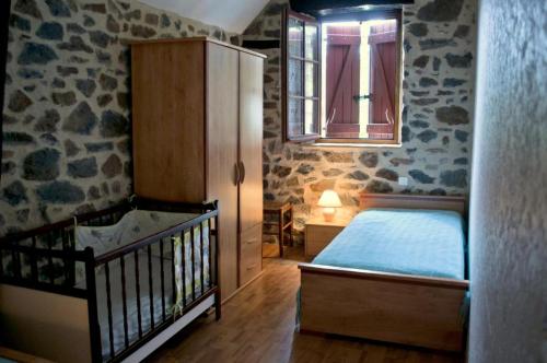 a bedroom with a bed and a window and a crib at Gîte de France Gîte de la plaine 3 épis - Gîte de France 6 personnes MAE-0334 in Altillac