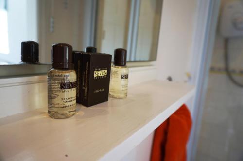 trzy butelki olejków eterycznych siedzące na blacie w łazience w obiekcie Ship Stores Guest House w mieście Clare