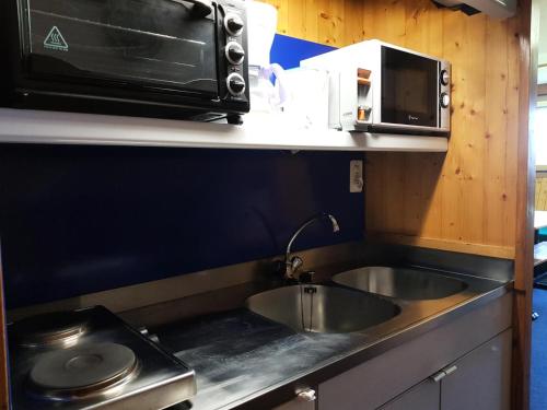 une cuisine avec un évier et un micro-ondes dans l'établissement Résidence Cascade - Studio pour 3 personnes à Arc 1600, ski aux pieds et proche des commerces MAE-1848, à Arc 1600