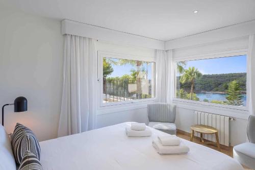 Habitación blanca con cama y ventana grande. en Villa Mar - Sol de Mallorca, en Sol de Mallorca