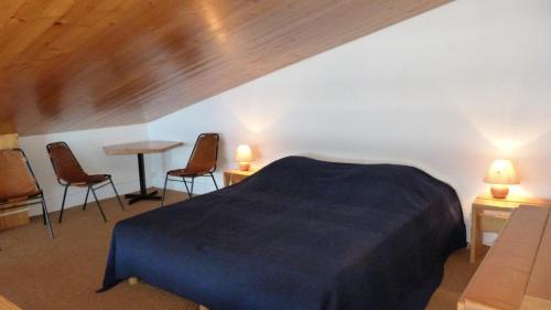 sypialnia z łóżkiem, 2 krzesłami i stołem w obiekcie Résidence Tournavelles - Appartement 2 pièces 7 personnes en duplex, au pied des pistes et des commerces, proche de l'ESF et de la garderie dans le villa MAE-1875 w mieście Arc 1800