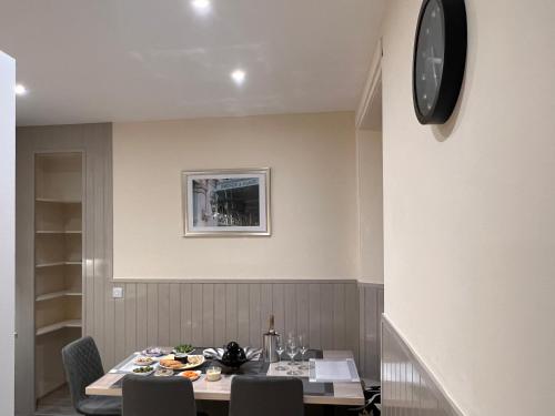 a dining room with a table and a clock on the wall at 85C Bongate in Jedburgh