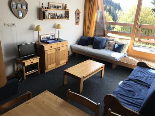 un salon avec un canapé et une télévision dans l'établissement Résidence Versant Sud - Appartement 2 pièces 7 personnes à Arc 1600 dans une résidence proche des pistes et des commerces MAE-1874, à Arc 1600