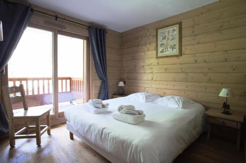 ein Schlafzimmer mit einem Bett mit zwei Handtüchern darauf in der Unterkunft Les Chalets du Gypse - Appartement CHALETS GYPSE B02 pour 8 Personnes 24 in Saint-Martin-de-Belleville