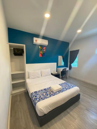 ein Schlafzimmer mit einem Bett und einer blauen Wand in der Unterkunft Hotel Apsara Temerloh Gateway in Temerloh
