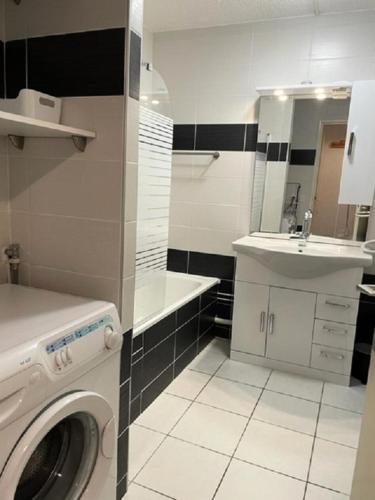 une salle de bain avec une machine à laver et un lavabo dans l'établissement Résidence Rond-point-pistes Ii - Trois pièces 7 pers. au rond point des pistes - 42B avec WIFI MAE-7094, à Orcières