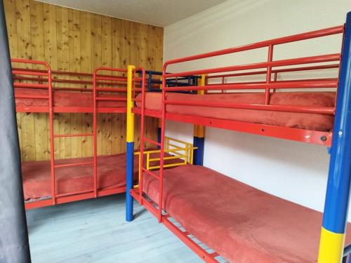 two red bunk beds in a room with wooden walls at Résidence Rond-Point-pistes I - 2 Pièces pour 8 Personnes 244 in Orcières