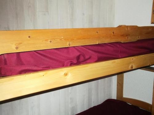 - un lit superposé en bois avec un drap rouge dans l'établissement Résidence Rond-point-pistes Ii - Maxi studio 4 pers. n° 55B au rond point des pistes 2 MAE-7264, à Orcières