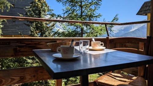 une table bleue avec deux tasses à café sur un balcon dans l'établissement Résidence Rond-point-pistes I - Maxi studio 6 pers. au rond point des pistes n° 143 A MAE-7314, à Orcières