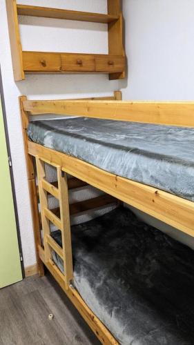 Ce lit superposé en bois se trouve dans un dortoir. dans l'établissement Résidence Rond-point-pistes Ii - Mini studio 4 pers N° 48B au rond point des pistes avec WIFI MAE-7394, à Orcières