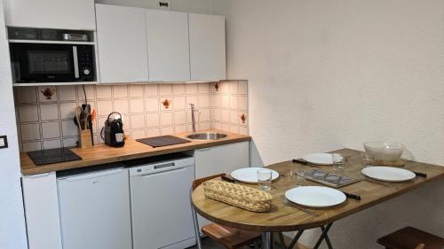- une petite cuisine avec une table et des plaques de cuisson dans l'établissement Résidence Rond-point-pistes Ii - Mini studio 4 pers N° 48B au rond point des pistes avec WIFI MAE-7394, à Orcières