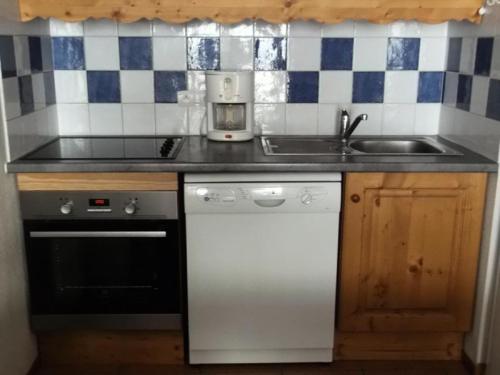 a kitchen with a sink and a white dishwasher at Résidence BALCONS DU SOLEIL - 3 Pièces pour 6 Personnes 404 in Orcières