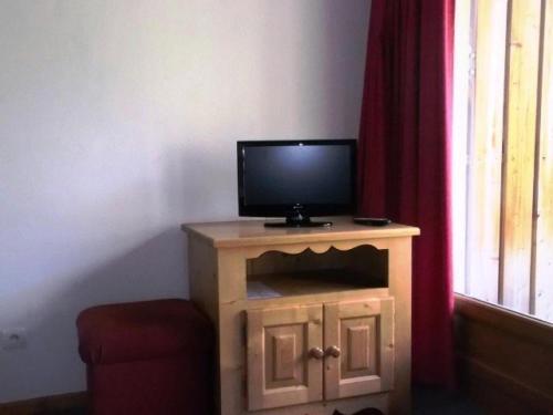 - une télévision installée au-dessus d'un meuble en bois dans l'établissement Résidence Balcons Du Soleil - TROIS PIECES 7 pers - RESIDENCE BALCONS DU SOLEIL n° 313 MAE-7434, à Orcières