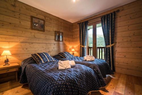 a bedroom with two beds in a room with wooden walls at Les Chalets du Gypse - Appartement CHALET GYPSE A03 pour 6 Personnes 44 in Saint-Martin-de-Belleville