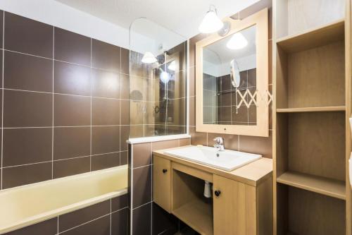 a bathroom with a sink and a mirror and a tub at Résidence Les Bergers - maeva Home - Studio 4 personnes - Sélection 34 in LʼHuez