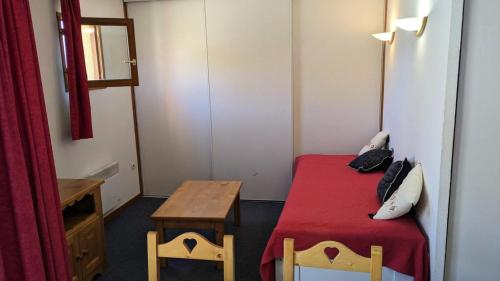 Kleines Zimmer mit einem Bett und einem Tisch in der Unterkunft Résidence BALCONS DU SOLEIL - 2 Pièces pour 4 Personnes 504 in Orcières