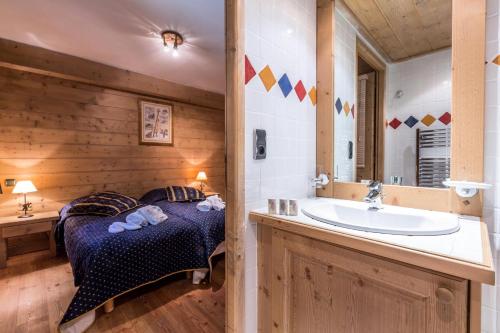 a bedroom with a bed and a tub and a sink at Les Chalets du Gypse - Appartement CHALET GYPSE C08 pour 8 Personnes 97 in Saint-Martin-de-Belleville