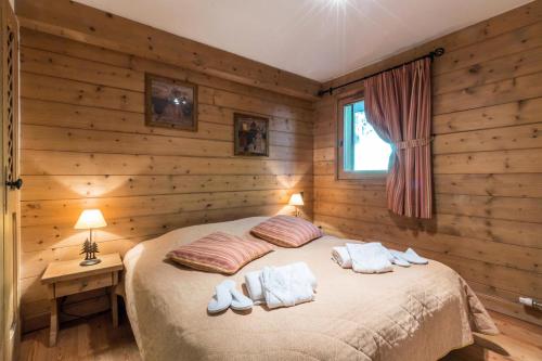 a bedroom with wooden walls and a bed with two pillows at Les Chalets du Gypse - Appartement CHALET GYPSE C08 pour 8 Personnes 97 in Saint-Martin-de-Belleville