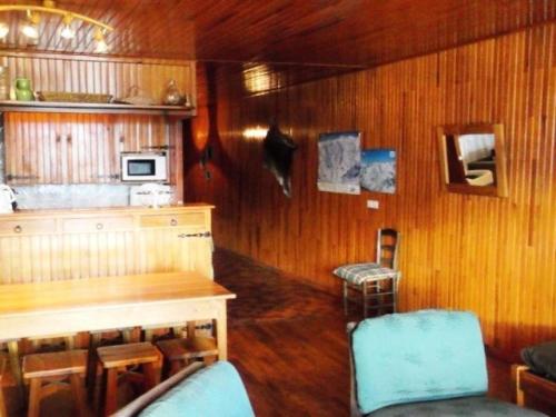 - une cuisine avec des murs en bois, une table et des chaises dans l'établissement Résidence Bellevue F - Trois pièces résidence BELLEVUE F à Orcières Merlette - Alpes du Sud MAE-7544, à Orcières