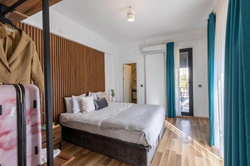 sypialnia z dużym łóżkiem z niebieskimi zasłonami w obiekcie Magesa Suites w mieście Antalya