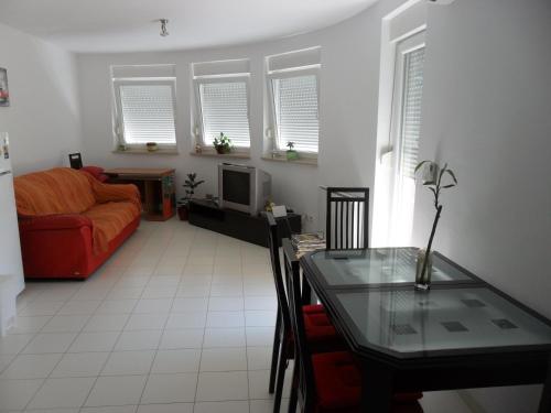 a living room with a table and a red couch at Apartment Lela in Pula