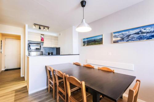 une cuisine et une salle à manger avec une table et des chaises dans l'établissement Résidence Les Constellations - maeva Home - Appartement 3 Pièces 8 Personnes - Selection MAE-0330, à La Plagne Tarentaise