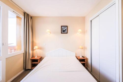 - une chambre avec un lit blanc et deux lampes dans l'établissement Résidence Les Constellations - maeva Home - Appartement 3 Pièces 8 Personnes - Selection MAE-0330, à La Plagne Tarentaise