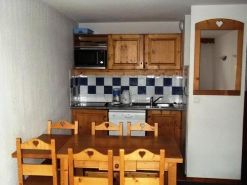 une cuisine avec une table en bois et une table et des chaises dans l'établissement Résidence Balcons Du Soleil - Trois pièces 6 pers balcons du soleil n° 211 MAE-7564, à Orcières