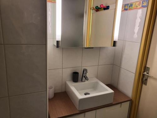 une salle de bain avec un lavabo blanc et un miroir dans l'établissement Résidence Rond-point-pistes Ii - T2 6 pers.au rond point des pistes 2 n°56 B avec WIFI MAE-8724, à Orcières