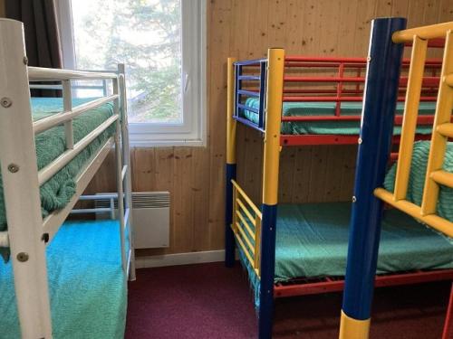 a room with three bunk beds and a window at Résidence Rond Point Pistes - Pièces 744 in Orcières