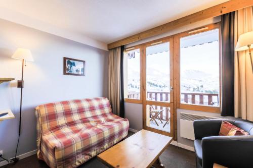 un salon avec un canapé et une fenêtre dans l'établissement Résidence Les Constellations - maeva Home - Appartement 2 Pièces 5 Personnes - Selection MAE-0341, à La Plagne Tarentaise
