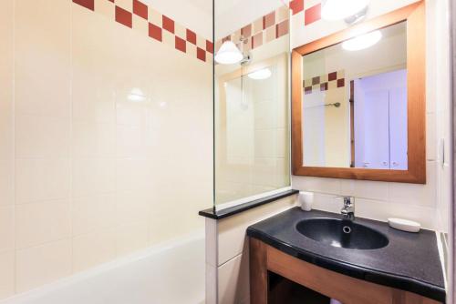 une salle de bain avec un lavabo, un miroir et une baignoire dans l'établissement Résidence Les Constellations - maeva Home - Appartement 2 Pièces 5 Personnes - Selection MAE-0341, à La Plagne Tarentaise