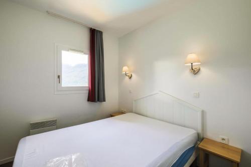 une chambre avec un lit blanc et une fenêtre dans l'établissement Résidence Le Thabor - maeva Home - Appartement 2 Pièces 5 Personnes - Confort MAE-0345, à Le Désert