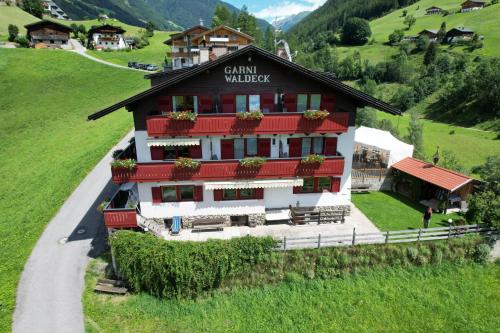 a building on a hill with flowers on the windows at Garni Waldeck in San Giacomo