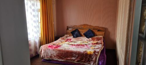 斯利那加的住宿－WOODENVILLE，一间卧室,床上放着鲜花