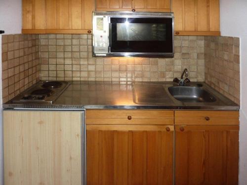 una cocina con fregadero y microondas en Résidence Orr Des Cimes - STUDIO SUR LES PISTES MAE-0554, en Les Orres