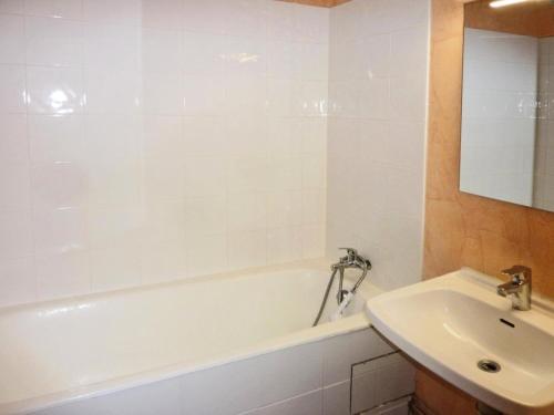 a white bathroom with a sink and a tub and a sink at Résidence LE PERESCUELLE - Studio pour 4 Personnes 624 in Les Orres
