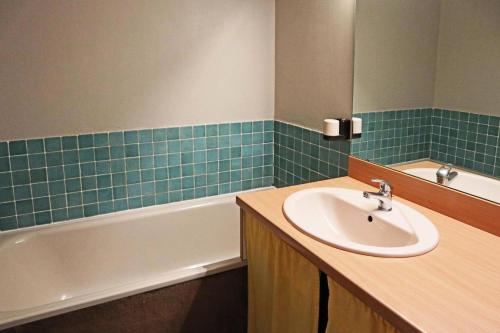 une salle de bain avec un lavabo et une baignoire dans l'établissement Résidence Orr Des Forets - 87 Orrianes des forets MAE-0534, aux Orres