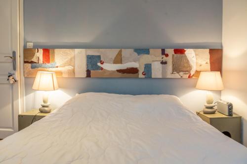 - une chambre avec un lit blanc et deux lampes dans l'établissement Maison de pêcheur Souffle de Mer, à Saint-Valery-sur-Somme