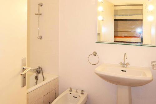 une salle de bain blanche avec un lavabo et un miroir dans l'établissement Résidence Le Silhourais - Appartement 2 pièces pour 6 personnes avec départ MAE-0604, aux Orres