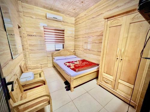 a small room with a bed and a cabinet at Nhà Nghỉ Thanh Thuý in Quang Tri