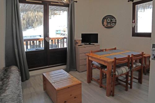 un salon avec une table à manger et une télévision dans l'établissement Résidence Orr Des Cimes - Superbe studio vue pistes centre station MAE-0594, aux Orres