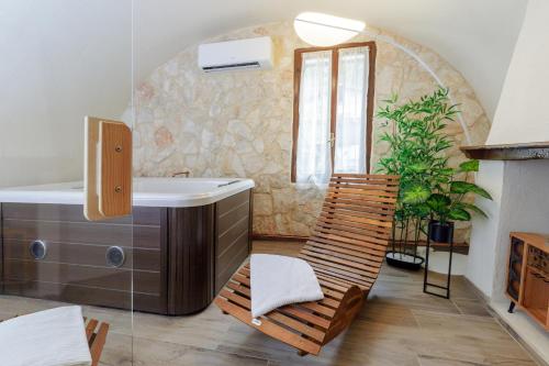 a bathroom with a tub and a sink and a chair at Le Case di Maggie in Isolabona