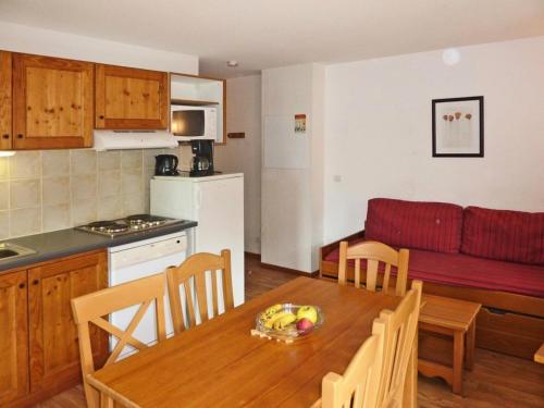 une cuisine et un salon avec une table et un canapé dans l'établissement Les Chalets De Bois Mean - Résidence le Bois Méan 2 pièces pour 6 personnes MAE-0704, aux Orres