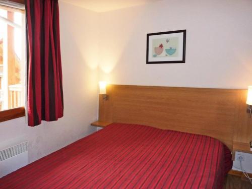 une chambre avec un lit avec une couverture rouge dans l'établissement Les Chalets De Bois Mean - Résidence le Bois Méan 2 pièces pour 6 personnes MAE-0704, aux Orres